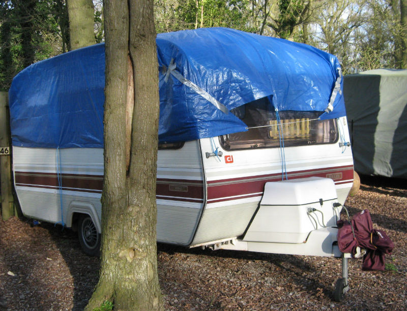 caravan covered with a tarpaulin