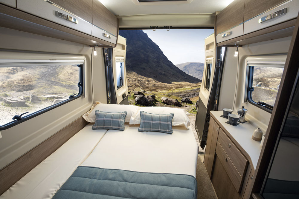 Bed made up and doors open in the Compass Avantgarde CV60 campervan