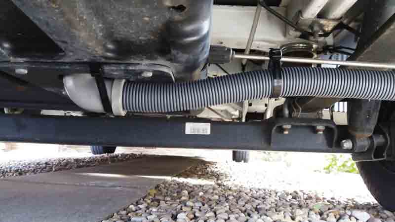 Image of a hose secured to the underside of a motorhome