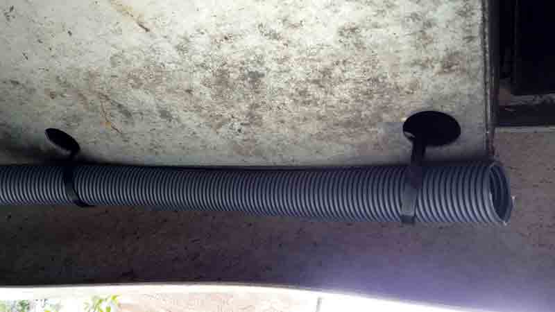 Image of a hose fixed into place underneath a motorhome
