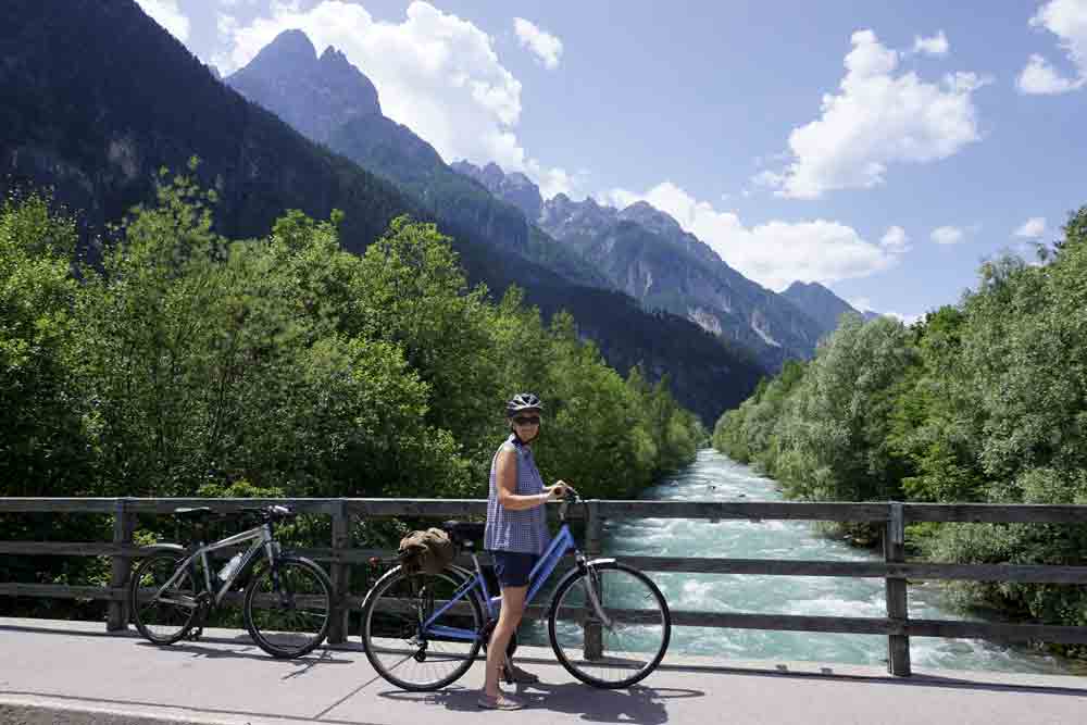 Image of a woman cycling in Austria with mountain scenery