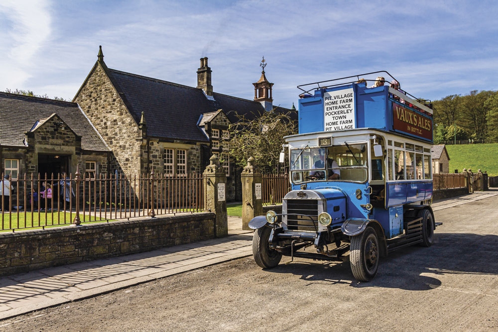 A bus carrying passengers at Beamish Museum's Pit Village