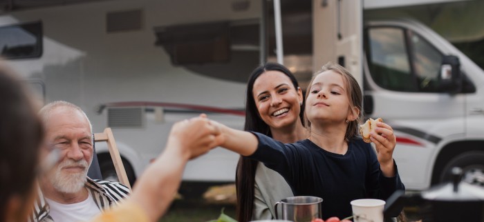A family sharing a meal by their motorhome