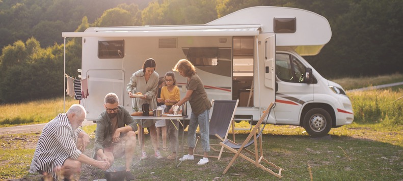 A family enjoying a meal by their motorhome