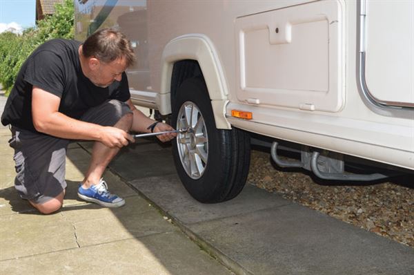 Undoing the wheel nuts on the caravan