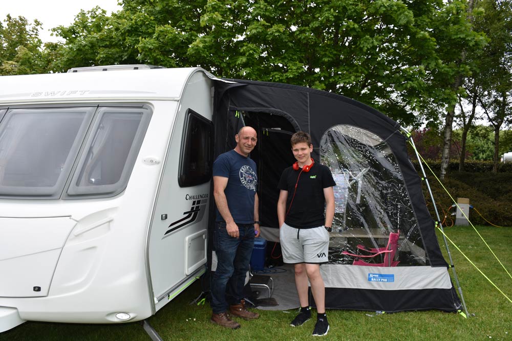 Father and son next to caravan