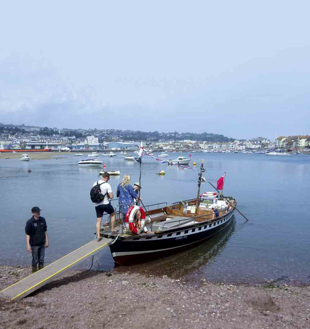 Image of people stepping onto a small boat in Devon