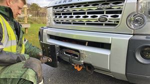 A towhitch is fixed to one of the two mounting plates at the front of the Land Rover