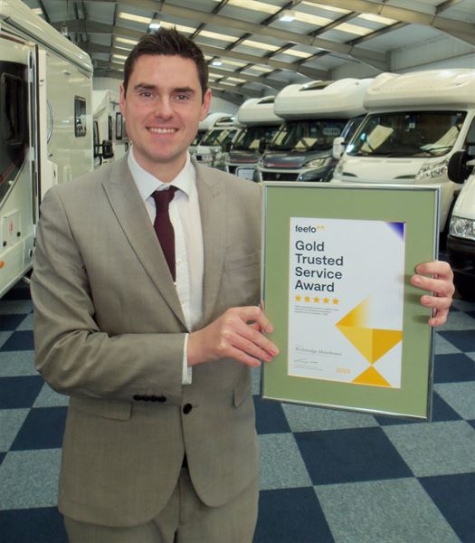 Manager Lance with the Feefo Gold Trusted Service Award (photo courtesy of Wellsbridge Motorhomes)