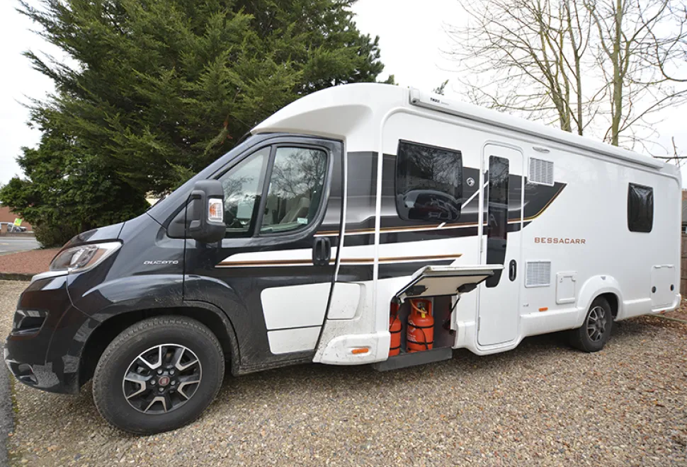 The side of a motorhome showing the gas locker door open with two cylinders inside