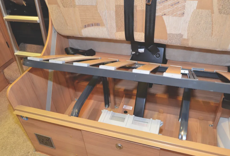 Motorhome seat with base cushion removed showing steel frame supports for seatbelts