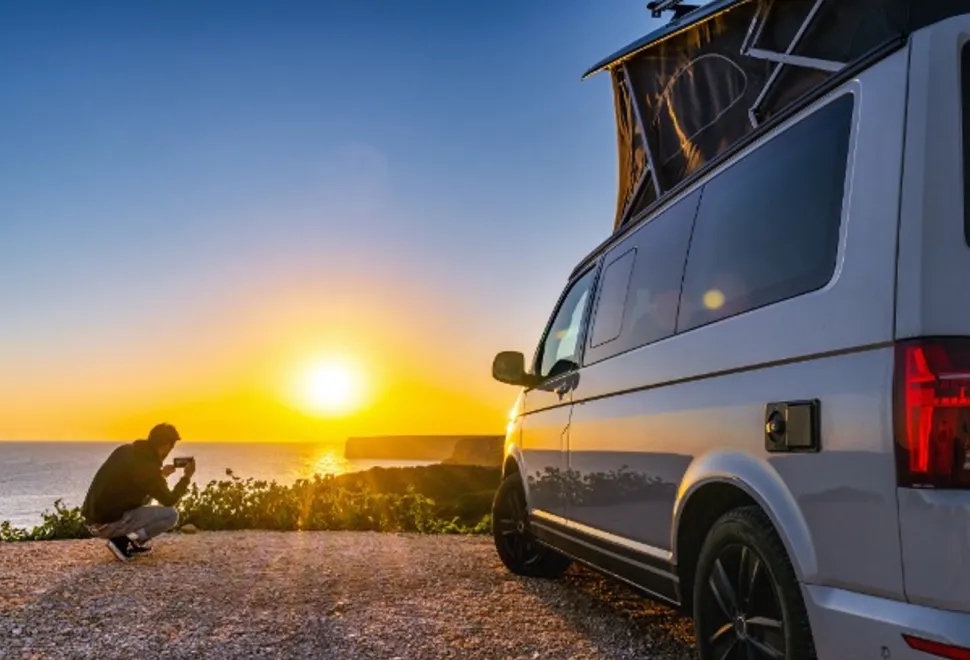 A campervan overlooking the sunset