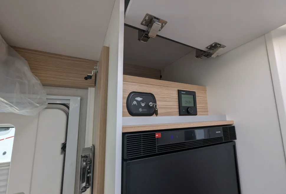 Control panel for the bed and heater and a little high-level storage above the fridge