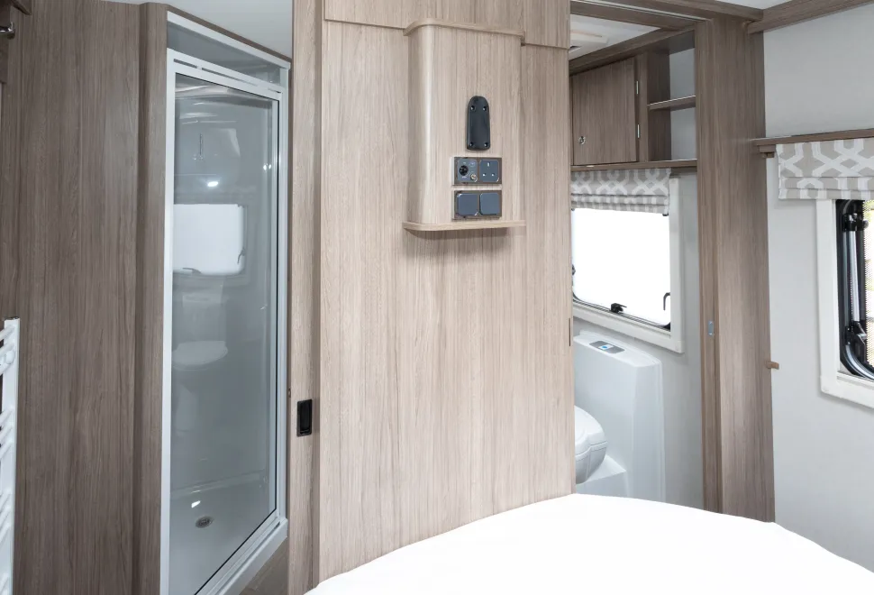 A TV bracket and connections are on the wall at the foot of the bed