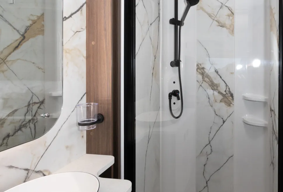 Marble-effect panels are on three sides of the shower cubicle