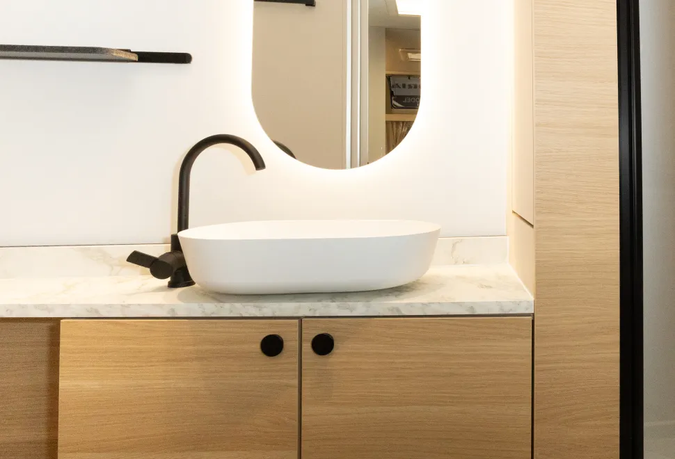 A backlit mirror above the washbasin