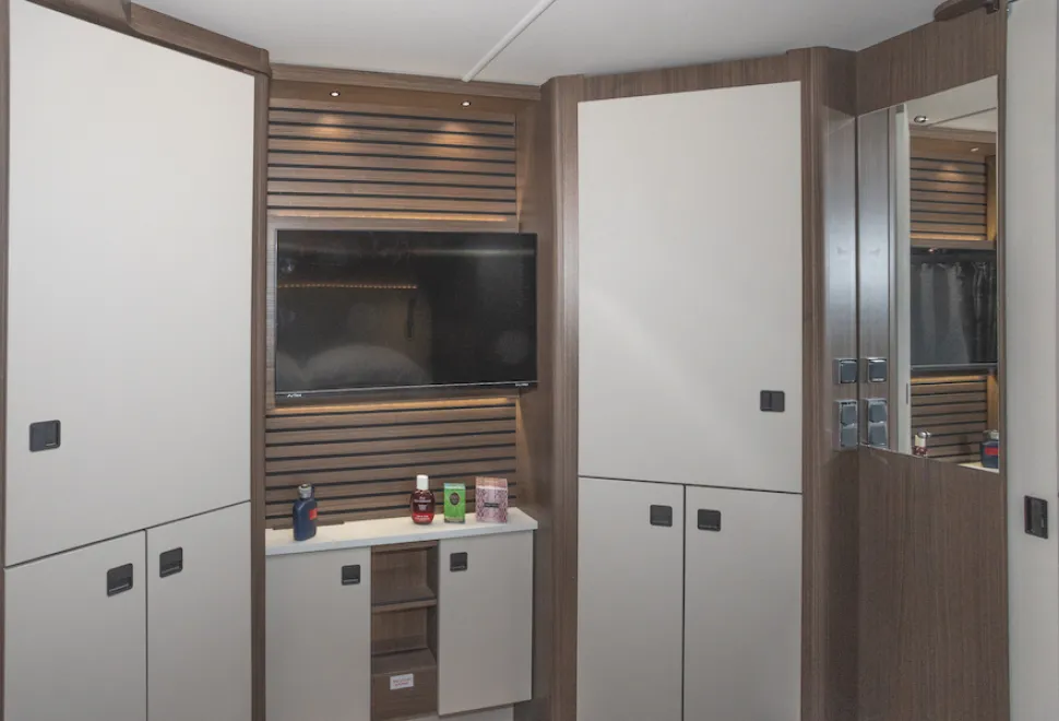 A suite of two large wardrobes and a dressing table, with the television bordered by acoustic panelling