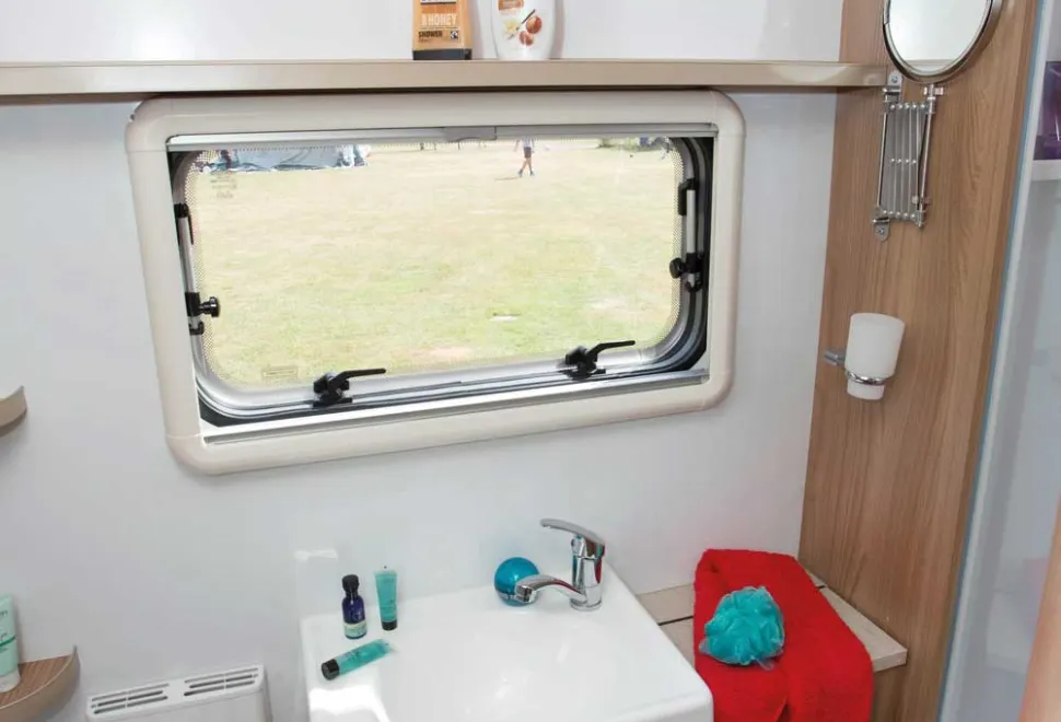 To-the-right-of-the-sink-is-a-deep-cabinet-containing-a-linen-bag,-ideal-for-storing-towels-34245