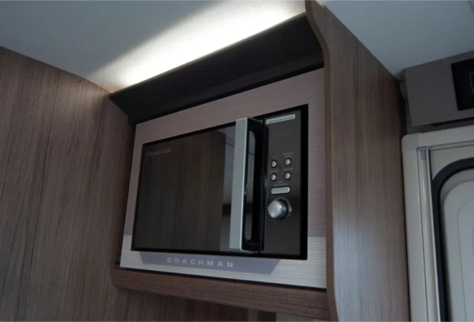 A-mirror-fronted-microwave-set-into-a-cabinet-with-light-above-it-08005