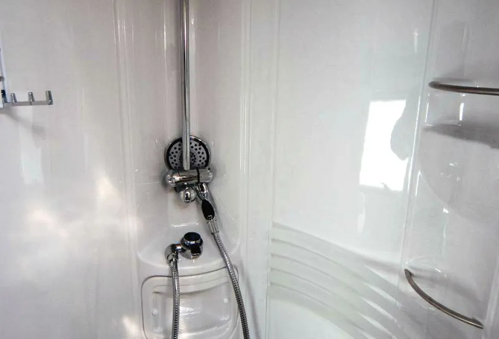 The-shower-is-circular-and-has-three-shelves-for-shampoo-bottles-23095