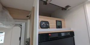 Control panel for the bed and heater and a little high-level storage above the fridge