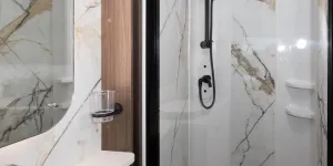Marble-effect panels are on three sides of the shower cubicle