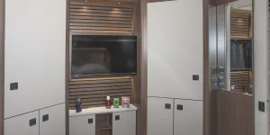 A suite of two large wardrobes and a dressing table, with the television bordered by acoustic panelling
