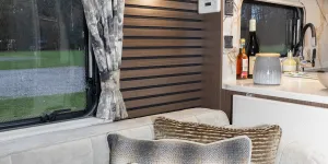 Three cushion fabrics, one with a golden lustre, one with a cosy wool weave and one with ridges of tactile material