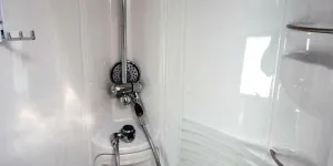 The-shower-is-circular-and-has-three-shelves-for-shampoo-bottles-23095