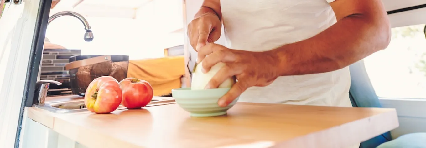 A man cooking in a campervan