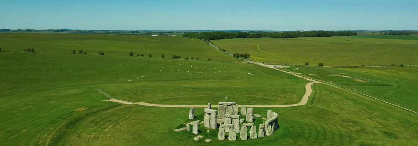 Aerial view of Stonehendge on a sunny day in summer with no people around. This is a historic site with a ring of standing stones, it was believed to be a burial site. Blue sky and space for text.