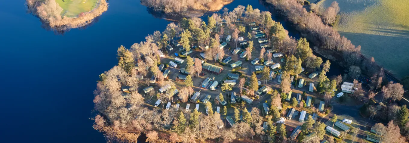 Caravan site park aerial view illuminated by summer sun on Scottish coastal ocean sea island in the highlands Scotland UK