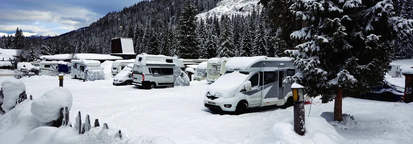 A motorhome parked on a snowy campsite in the Italian Tirol