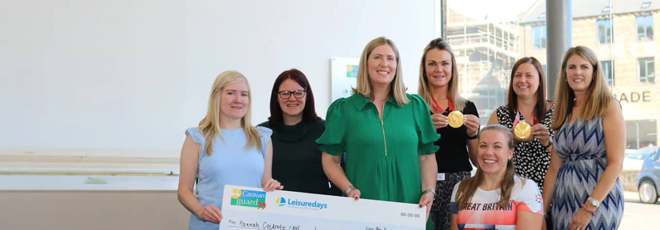 Caravan Guard associate director Laura Wilby presents Hannah Cockroft CBE with a £2,000 sponsorship cheque, alongside staff.