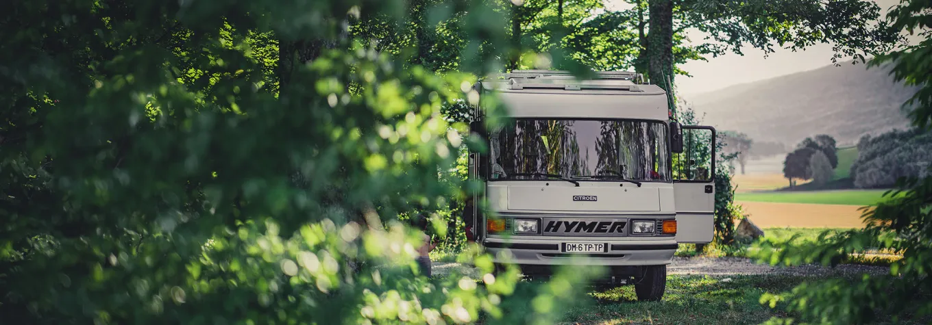 Old motorhome parked in woodland