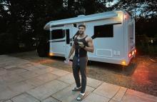 Tommy fury standing next to a motorhome