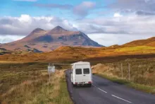 image of a campervan driving down a scenic road