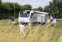 image of a family playing around a caravan