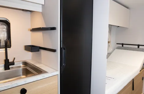 The tall fridge aft of the kitchen
