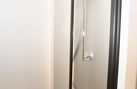 A towel rail runs across the roof of the shower compartment