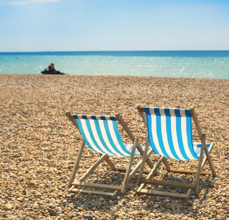 Two blue beach chairs, Brighton, England.