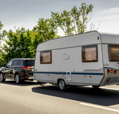 Caravan trailer on a freeway road. Family vacation travel, holiday trip in motorhome RV.