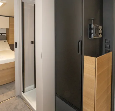 The fridge/freezer is alongside the shower