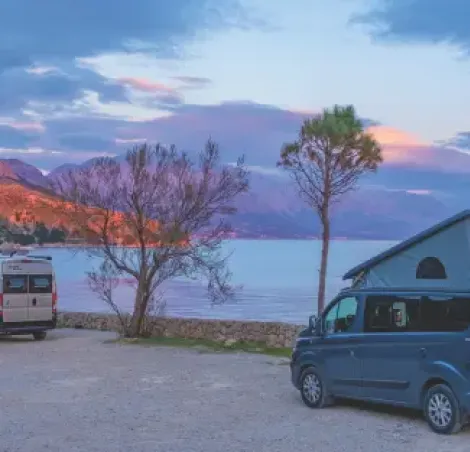 image of two campervans parked up by the sea
