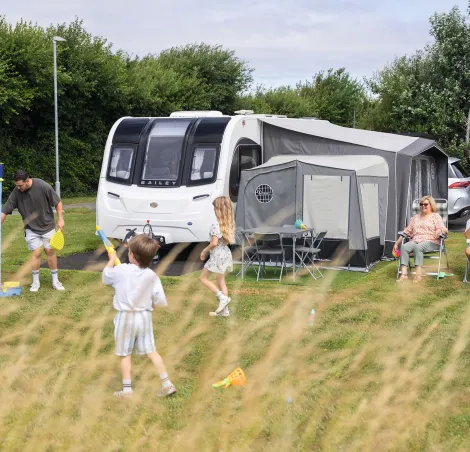 image of a family playing around a caravan