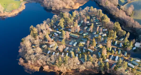 Caravan site park aerial view illuminated by summer sun on Scottish coastal ocean sea island in the highlands Scotland UK