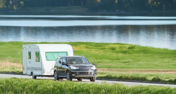 Car towing a camper on a sunny day