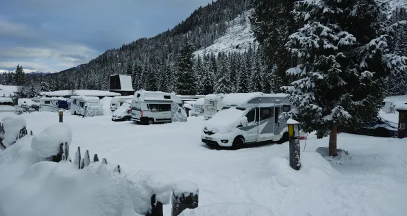 A motorhome parked on a snow covered campsite in the Italian Tirol