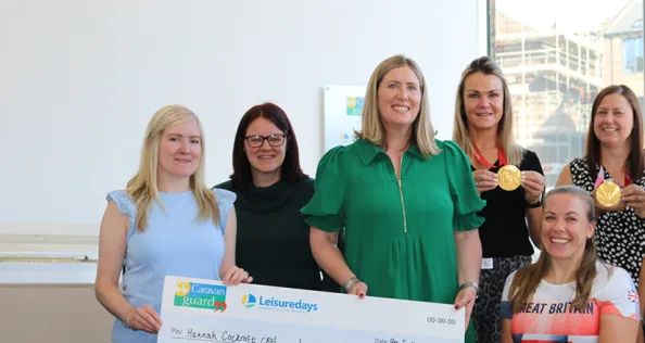 Caravan Guard associate director Laura Wilby presents Hannah Cockroft CBE with a £2,000 sponsorship cheque, alongside staff.