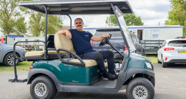 Danny Dyer on a golf cart at a Kent seaside caravan park